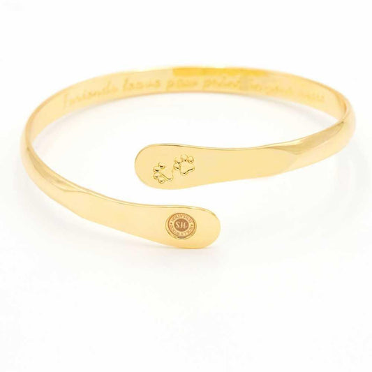 Gold paw print engraved cuff bracelet with small oval logo medallion