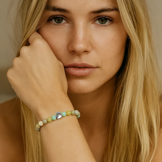 Beaded paw charm bracelet on modelโs wrist with pastel beads and silver charm