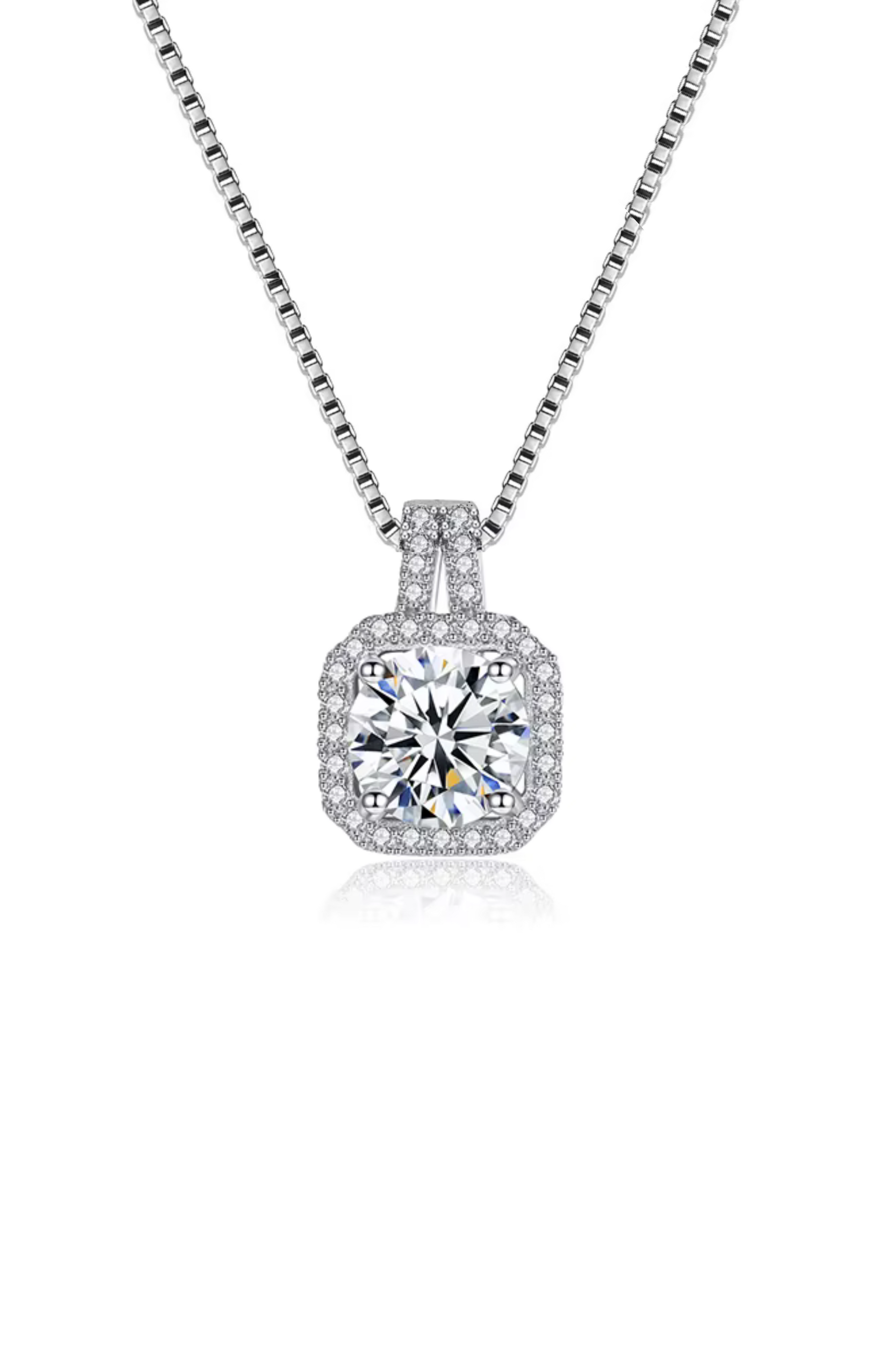 The Two Carat Halo Cubic Zirconia Pendant Necklace features a silver chain with a square-shaped pendant, showcasing a large round center stone encircled by smaller CZ stones.