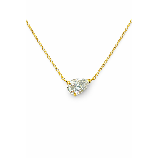 Gold necklace with a clear teardrop-shaped pendant on a white background