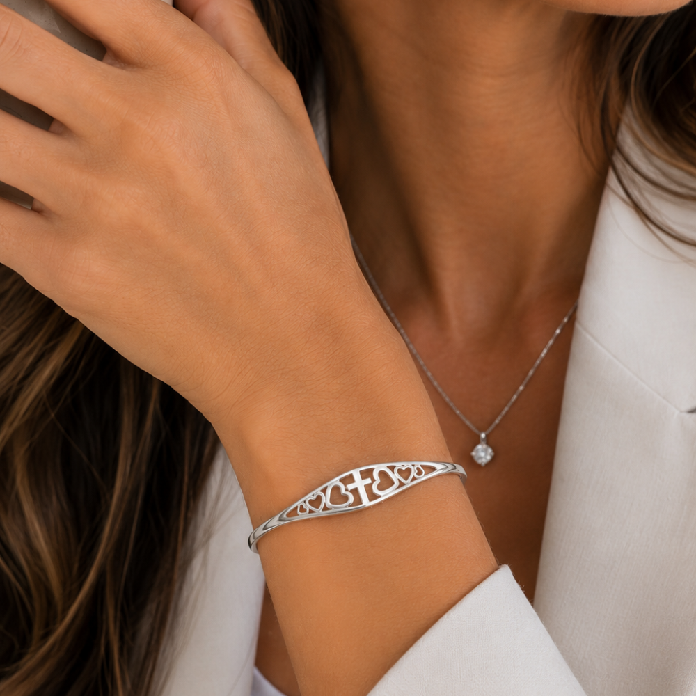 Silver faith bracelet cuff featuring cross and heart engraving along the band