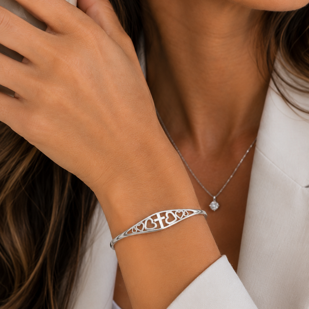 Silver-tone adjustable cuff bracelet with ornate cross-and-heart engraved pattern