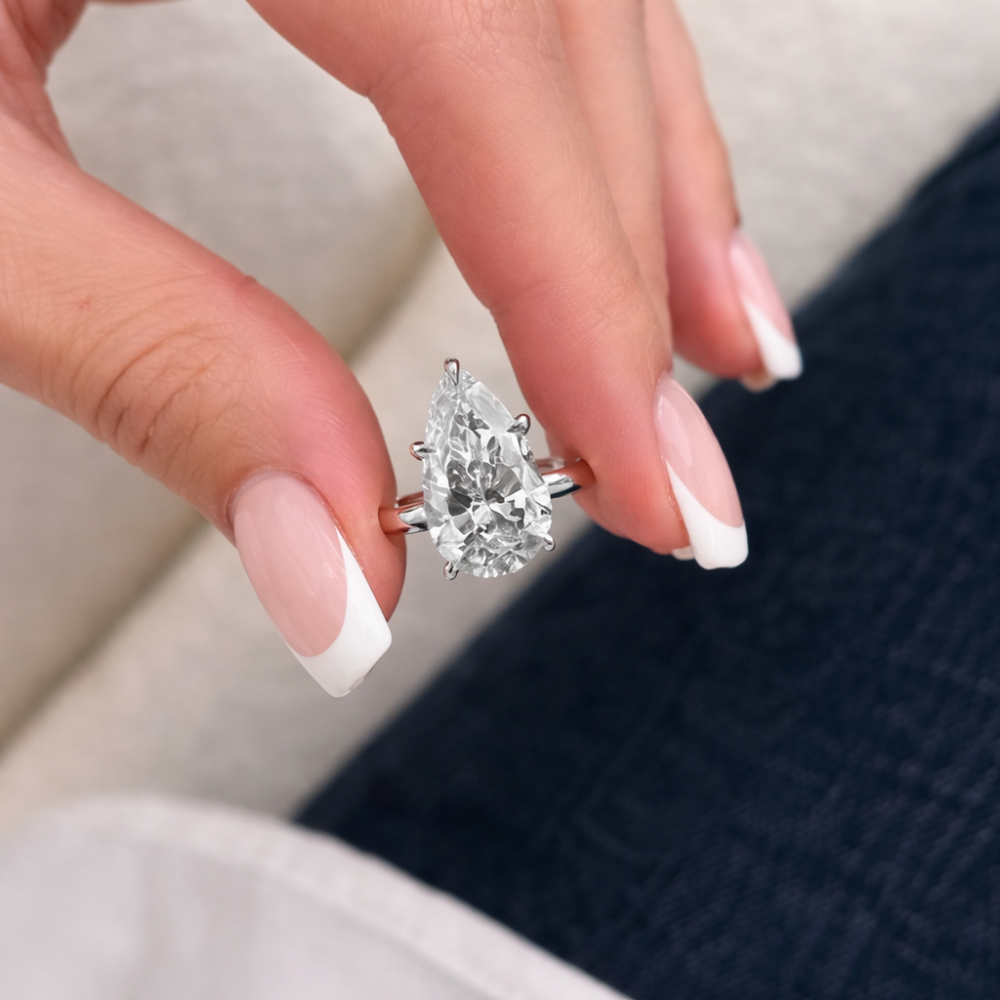 Pear-cut moissanite ring with a large teardrop stone, silver-tone prong setting.