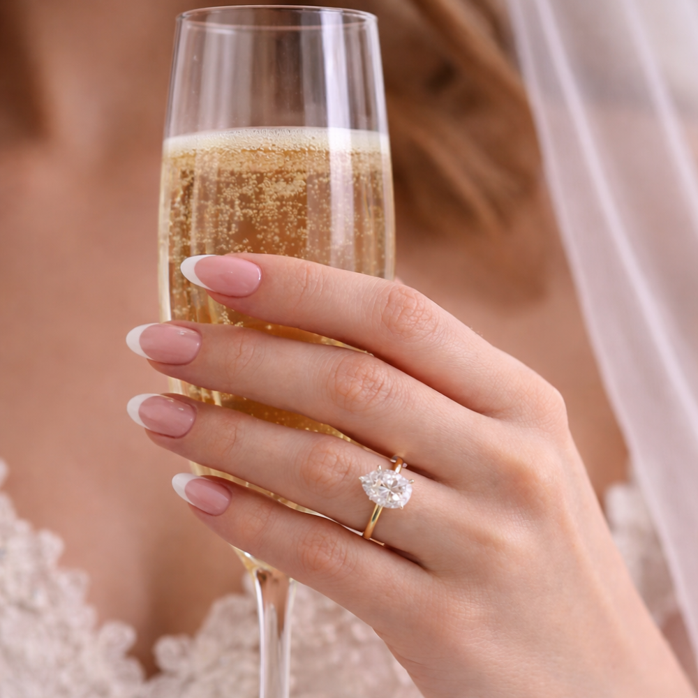 Gold-tone pear-cut moissanite ring with a teardrop stone and slim band.