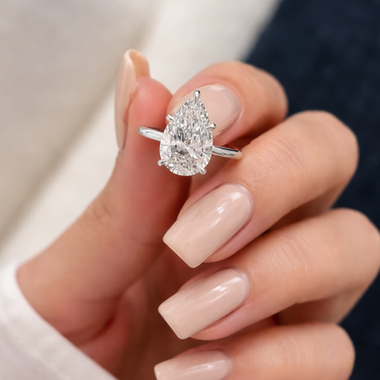 Silver-tone ring with faceted pear-shaped gemstone in prong setting