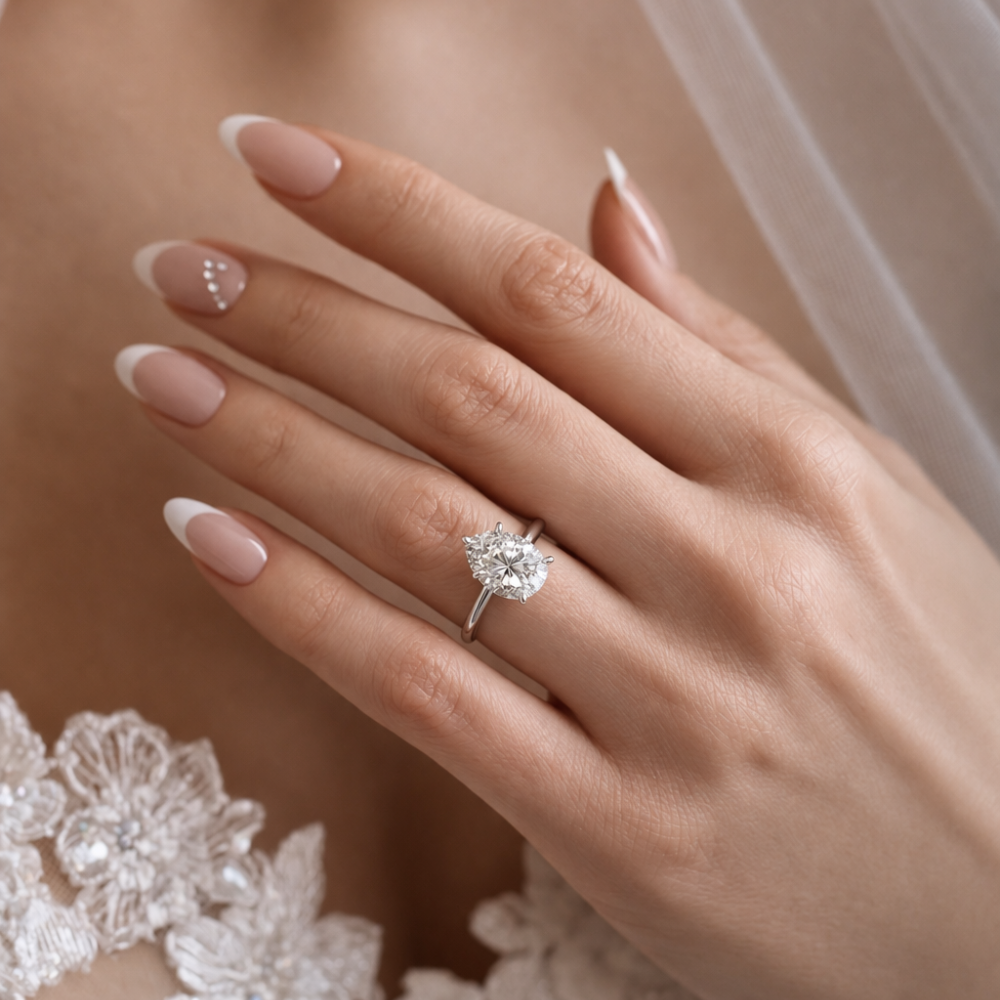Silver-tone ring with faceted pear-shaped gemstone on hand