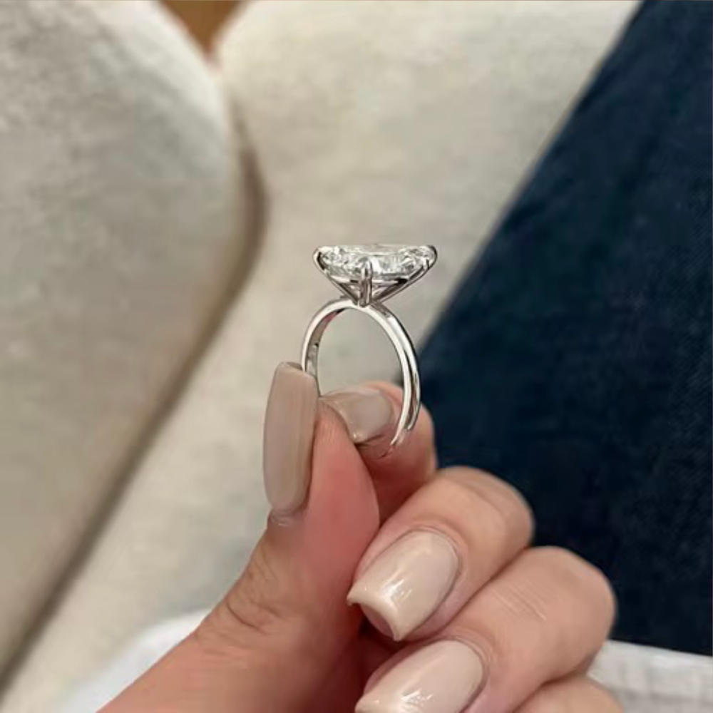 Pear-cut moissanite ring in silver-tone setting, open gallery under the center stone.