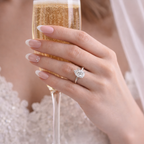 Silver-tone pear-shaped gemstone ring on hand holding sheer gold pouch
