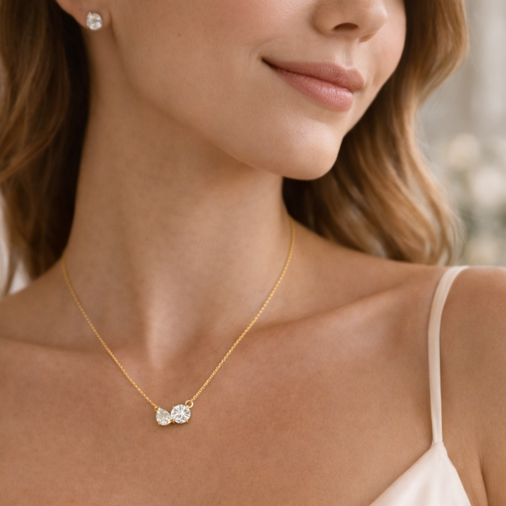 Gold vermeil necklace on model chest, pear- and round-cut clear stones pendant