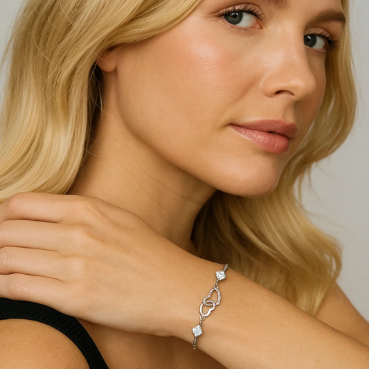 A woman with long blonde hair wears a black sleeveless top and showcases the I Love You Bracelet with Cubic Zirconia on her wrist, her hand resting gently on her shoulder.