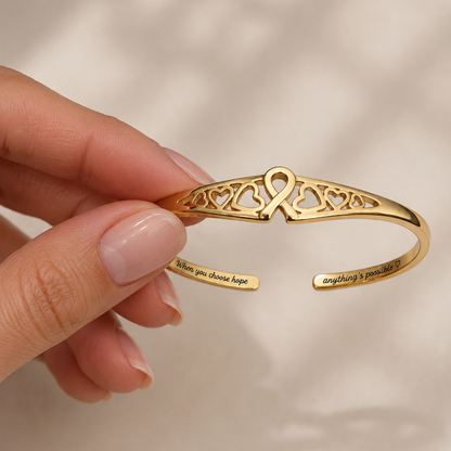 Gold engraved adjustable cuff bracelet detail with ribbon heart filigree center