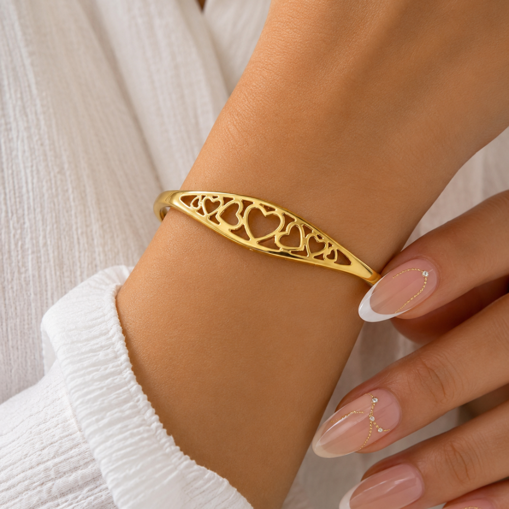 Gold adjustable heart cuff bracelet close-up with heart cutout filigree on the band