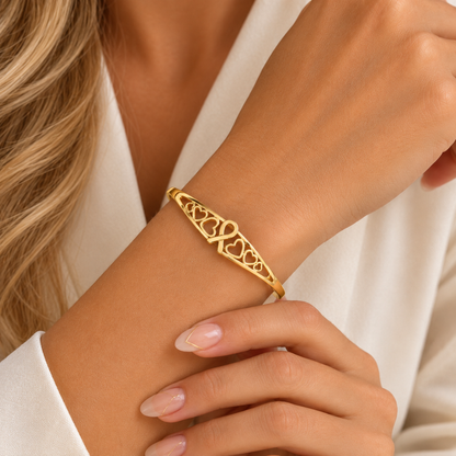 Gold open cuff bracelet with heart lattice design and ribbon symbol