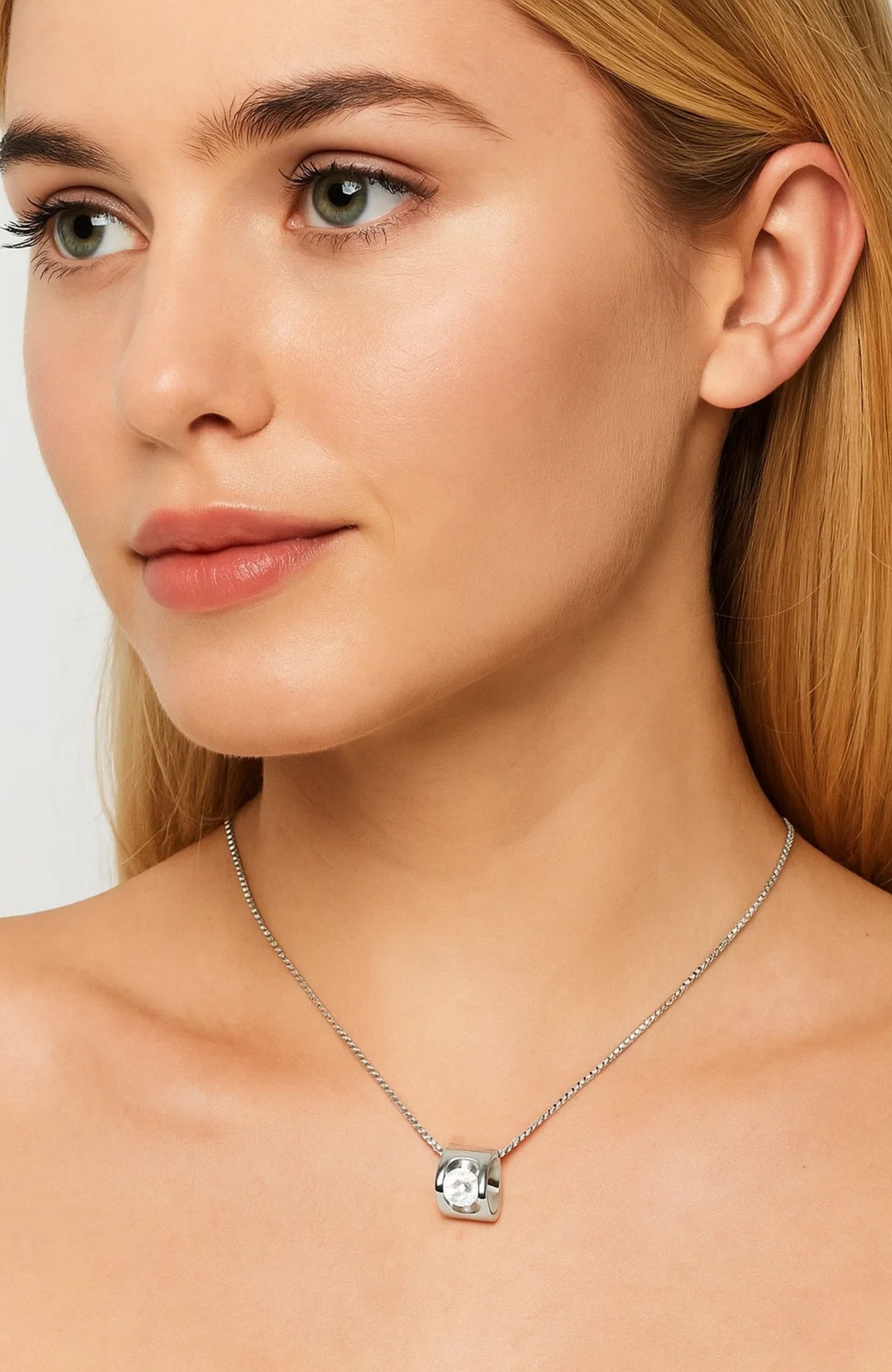 A woman with long blonde hair wearing the elegant Evelyn Zirconia Heart Pendant Necklace.