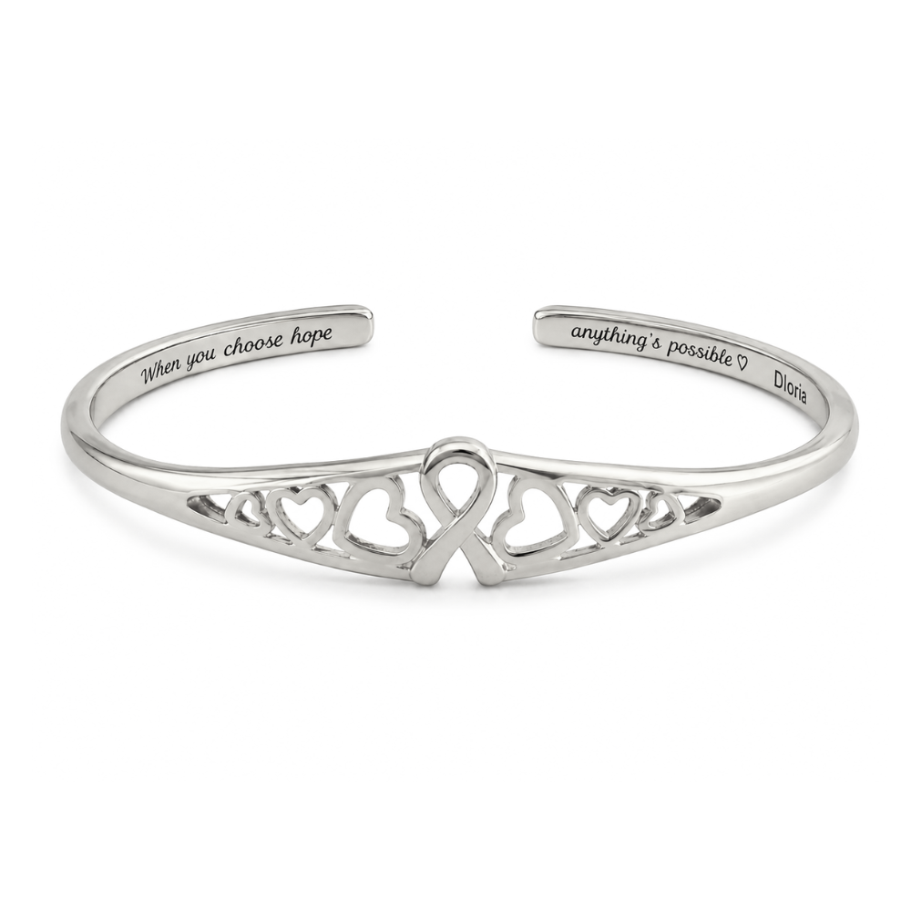 Silver engraved adjustable cuff bracelet with heart cutout ribbon motif on the front