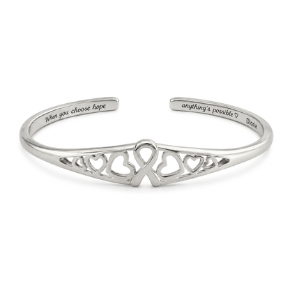 Silver engraved adjustable cuff bracelet with heart cutout ribbon motif on the front