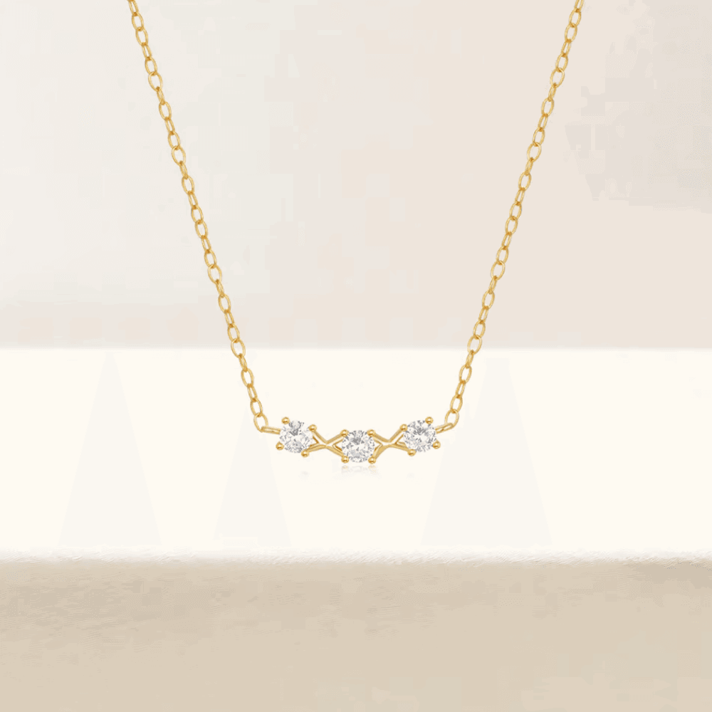 Gold-tone necklace with three small round cubic zirconia stones at center