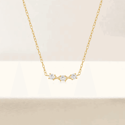 Gold-tone necklace with three small round cubic zirconia stones at center