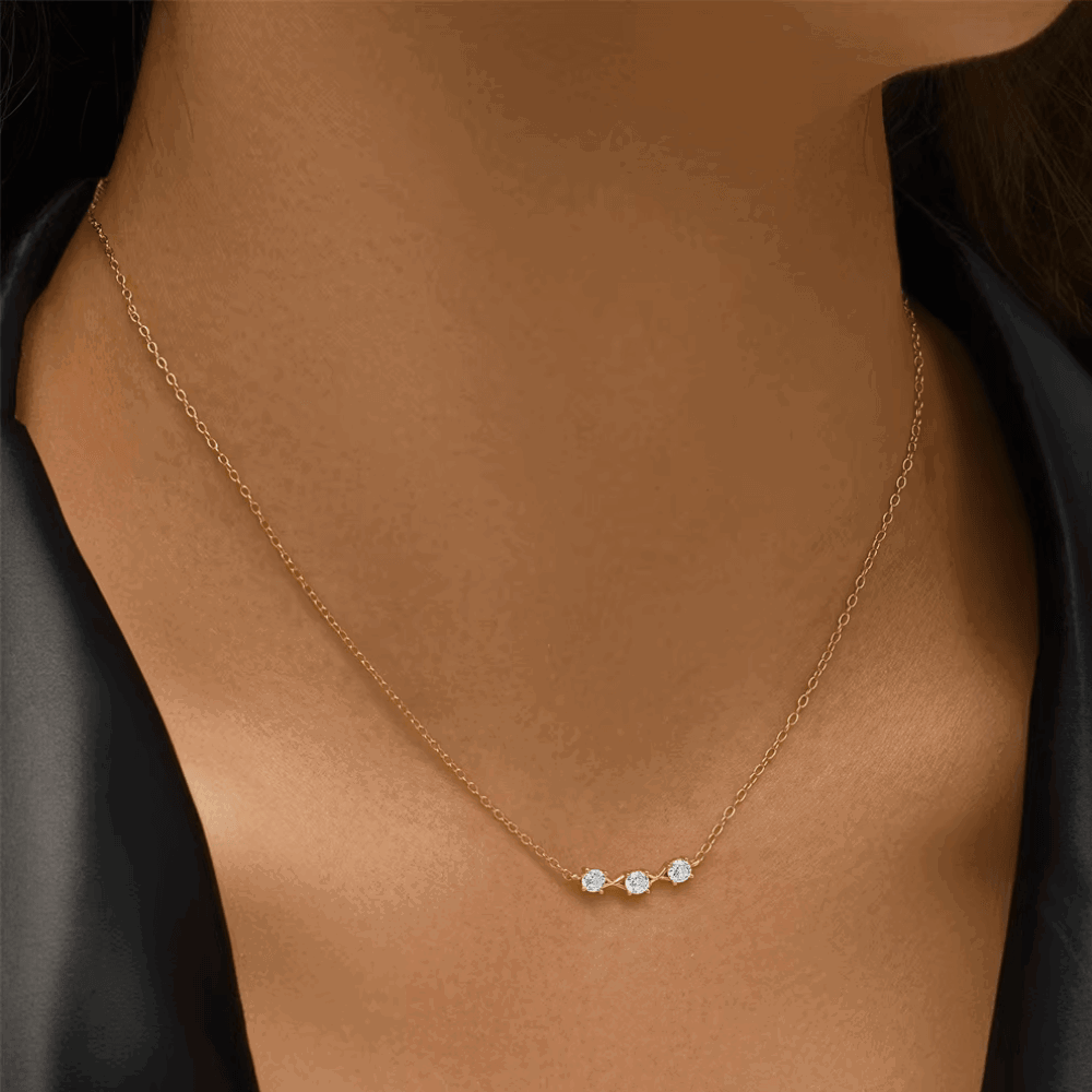 Three-stone cubic zirconia necklace with thin gold chain on model
