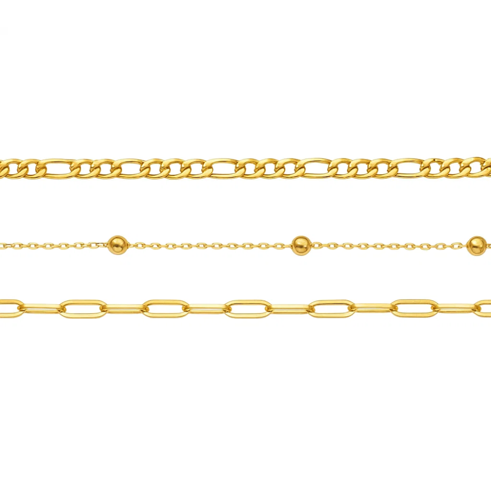 Close-up view of three gold-tone bracelet chains with bead and link details
