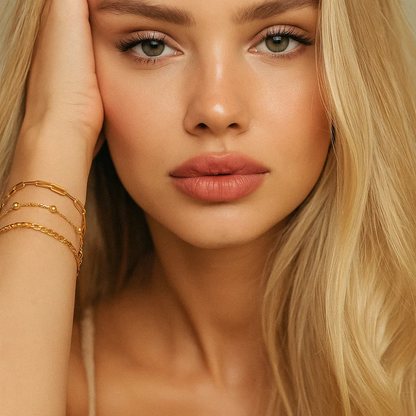 Three gold-tone bracelets stacked together on wrist