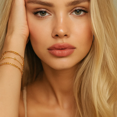 Three gold-tone bracelets stacked together on wrist