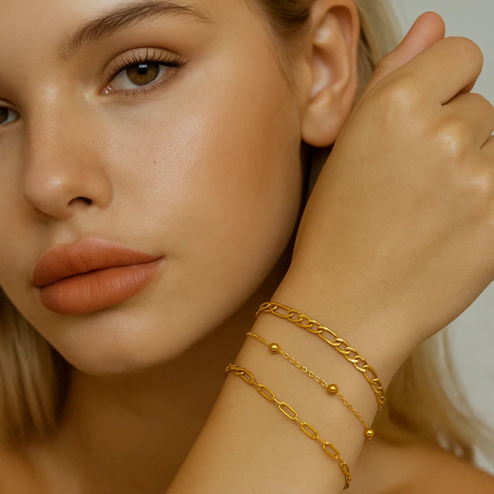 Gold-tone bracelet trio stacked on wrist with different chain link styles