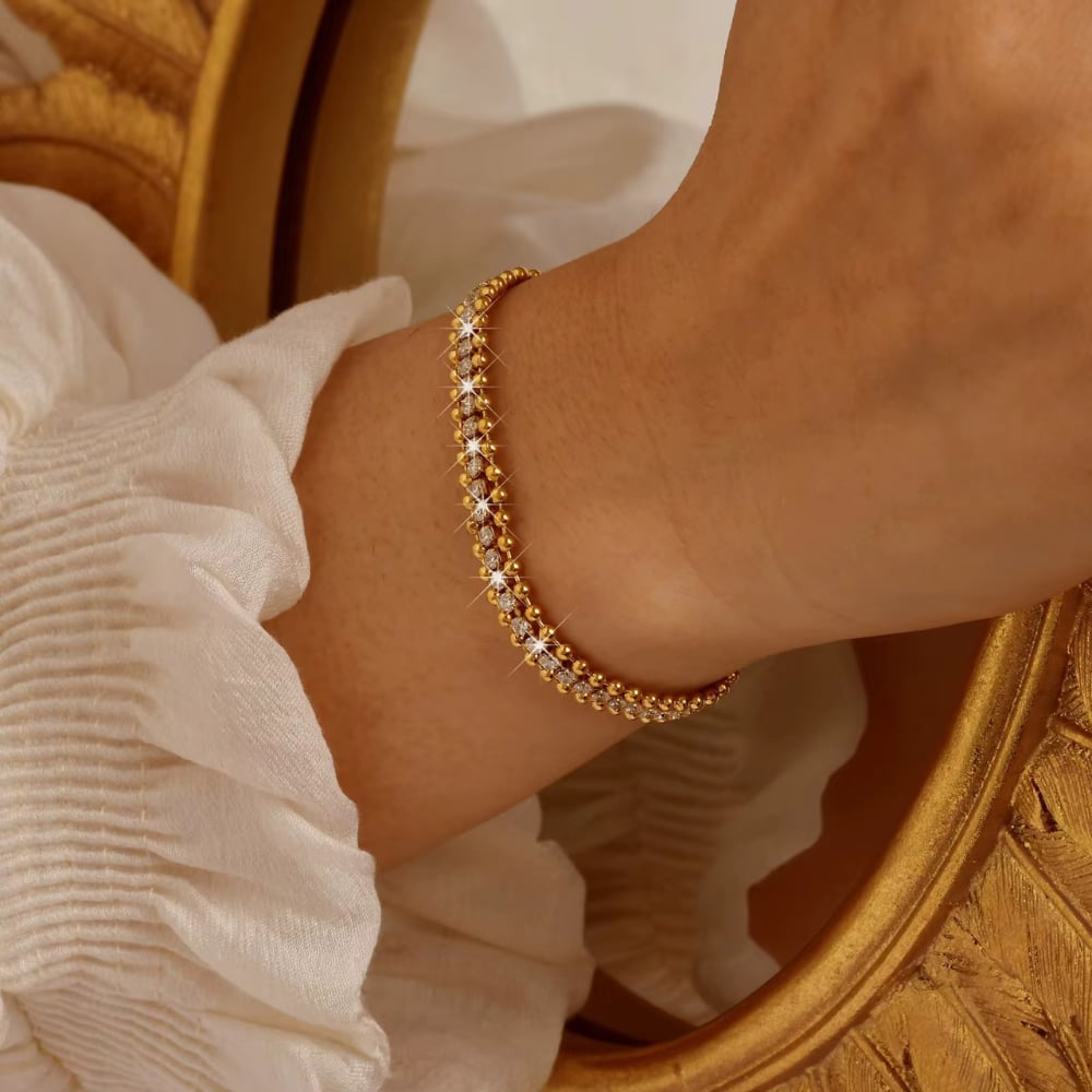 Gold-tone CZ chain bracelet with small round stones, adjustable link fit on wrist.