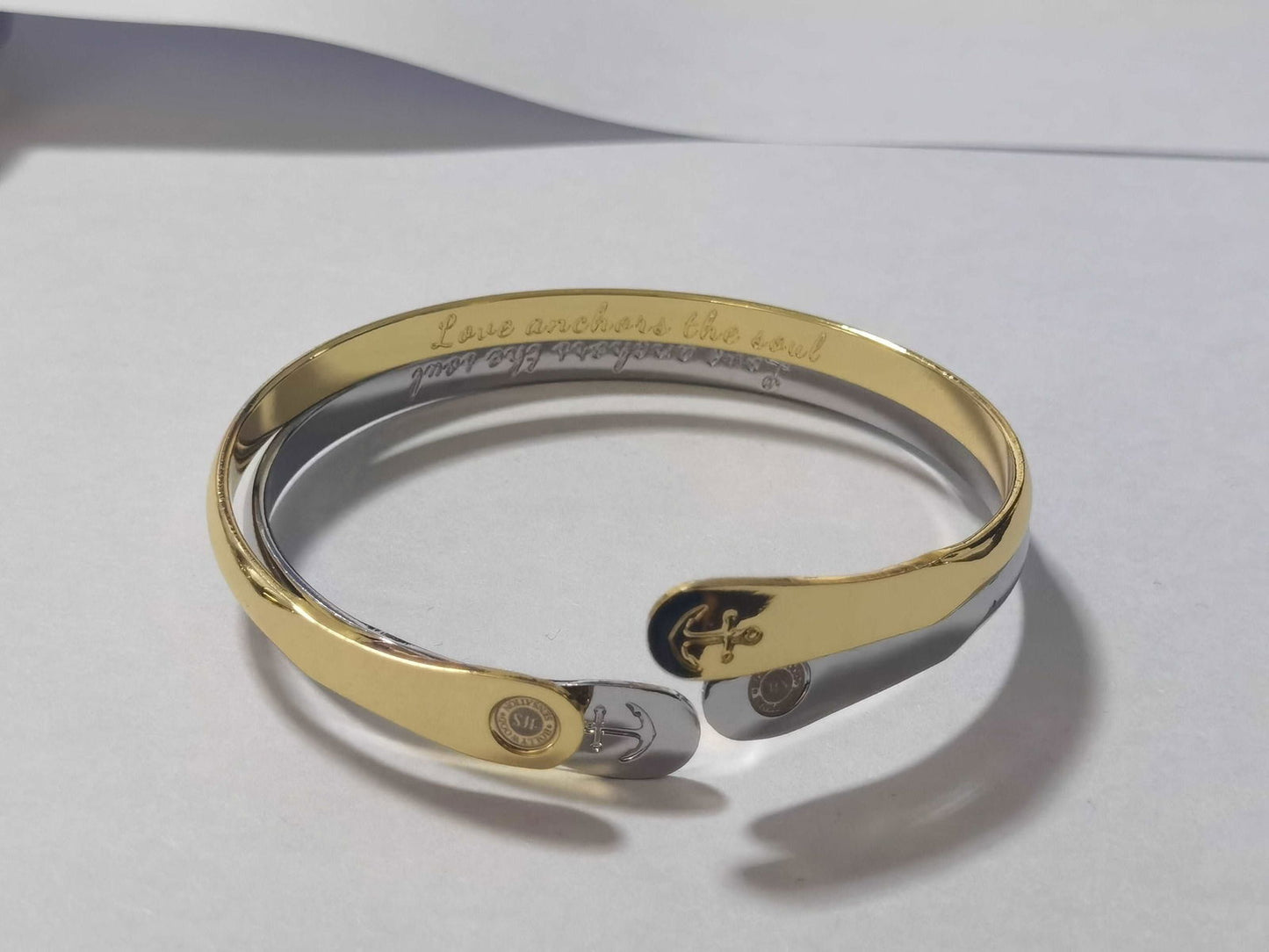 Gold tone anchor bangle bracelet with engraved medallion and anchor details