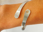 Silver anchor cuff bracelet on wrist with oval charm plate detail