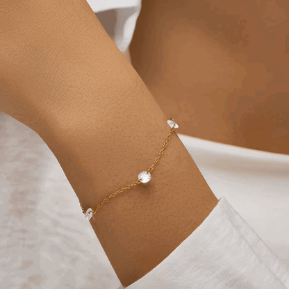 Gold-tone bracelet with three clear oval cubic zirconia charms on link chain