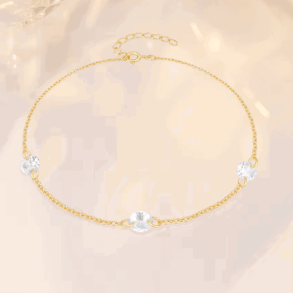 Gold-tone tennis bracelet with three clear oval cubic zirconia charm accents