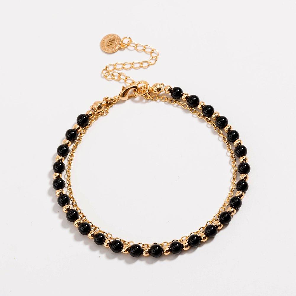 Gold beaded friendship bracelet with black beads and extended chain clasp