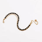 Gold beaded friendship bracelet with black beads and lobster-style clasp