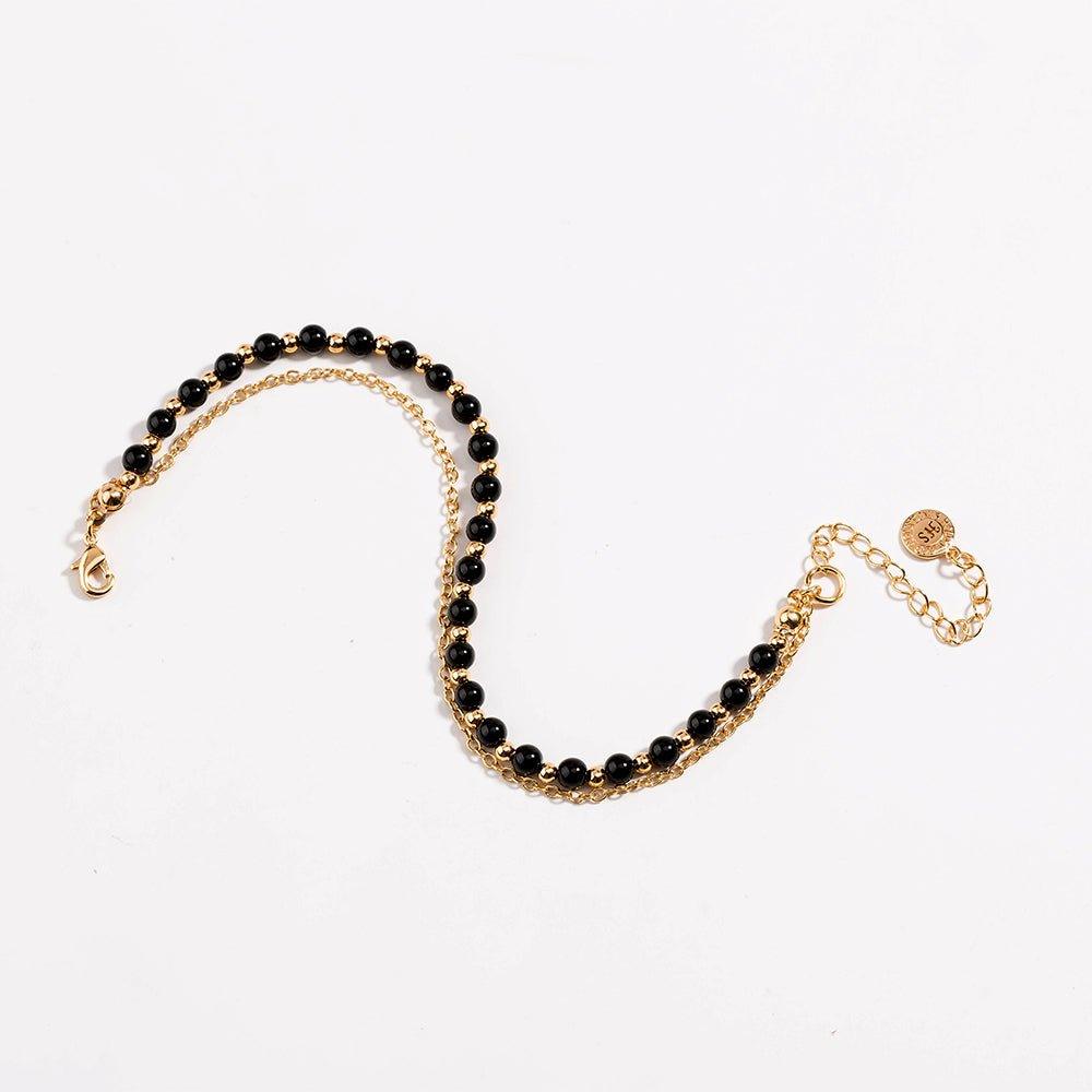 Gold beaded friendship bracelet with black beads and lobster-style clasp