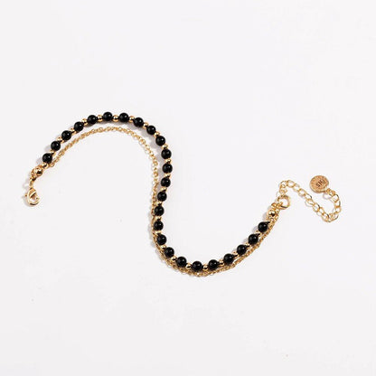 Gold beaded friendship bracelet with black beads and lobster-style clasp