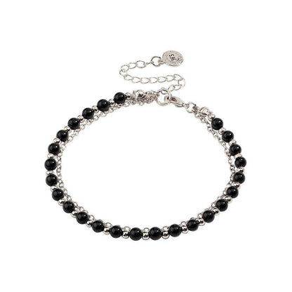 Silver-tone beaded friendship bracelet with black beads and round charm tag clasp