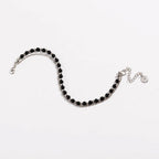 Silver beaded friendship bracelet with black beads and small round charm at end