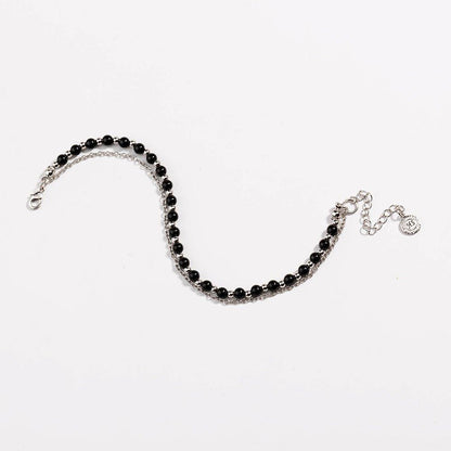 Silver beaded friendship bracelet with black beads and small round charm at end