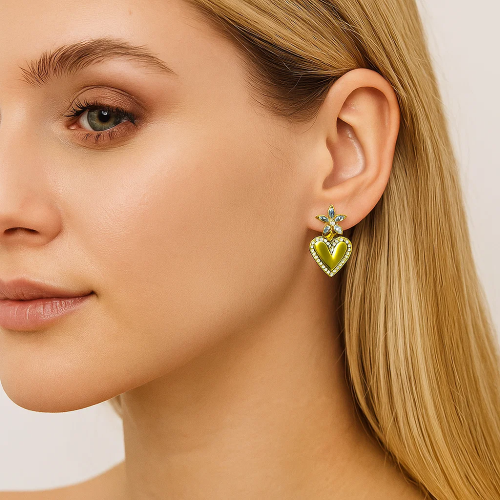 Gold heart drop earrings with green crystal accents and heart dangle on ear