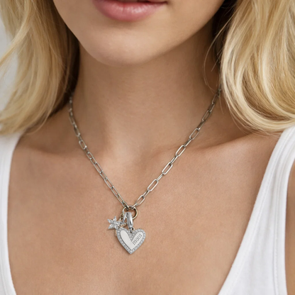 Silver heart pendant necklace with flower charm and MOM text pendant, close-up worn