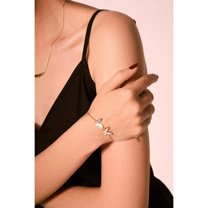 Gold butterfly bracelet on wrist with three butterfly charms and white shell inlay