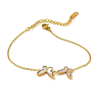 Gold chain bracelet with three butterfly charms and white shell inlay accents