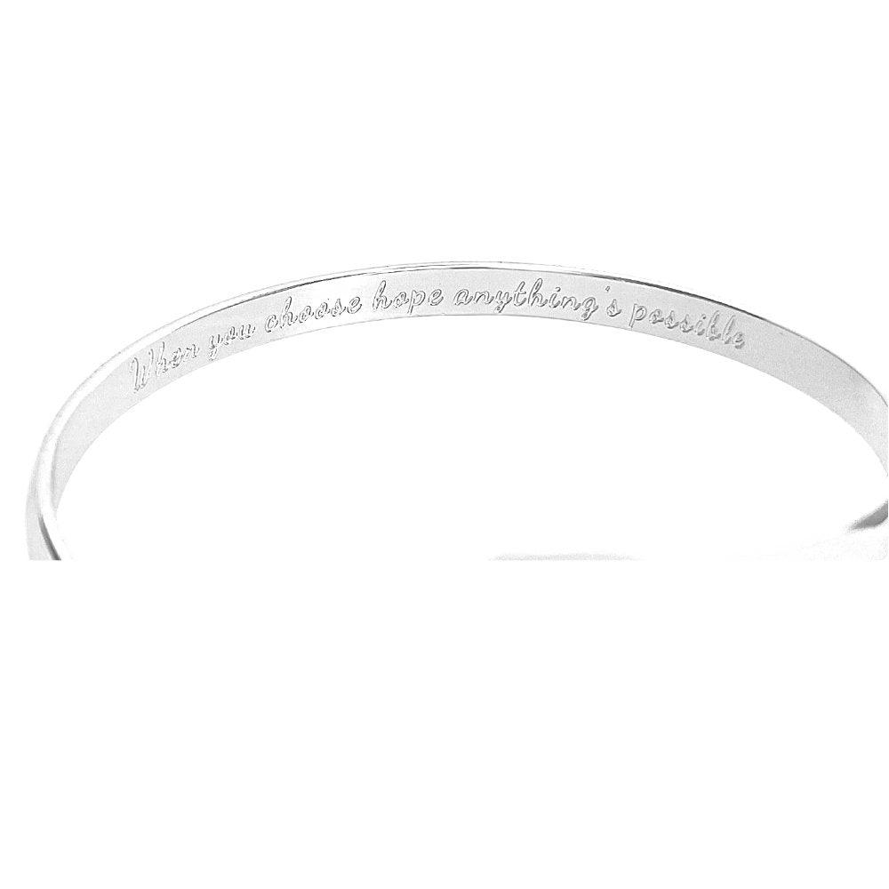 Silver engraved bracelet cuff showing inner message, ribbon emblem at center