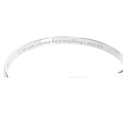 Silver engraved bracelet cuff showing inner message, ribbon emblem at center