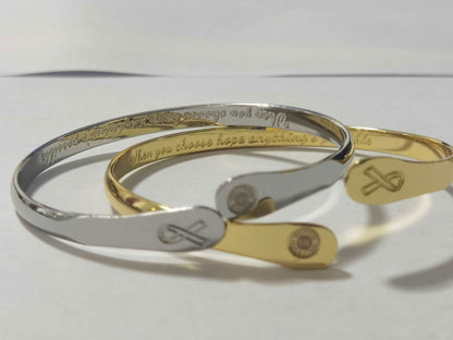 Stacked engraved bracelets, silver and gold cuffs with round logo and charm