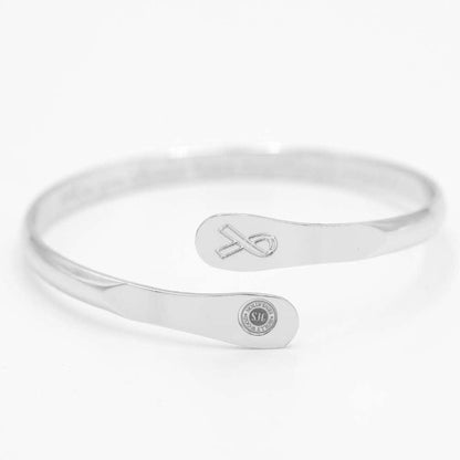 Silver awareness bracelet with ribbon charm and oval plaque medallion