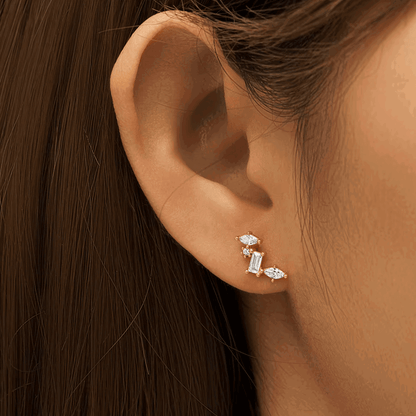 Silver-tone celestial cluster CZ earrings on ear with baguette and oval stone shapes