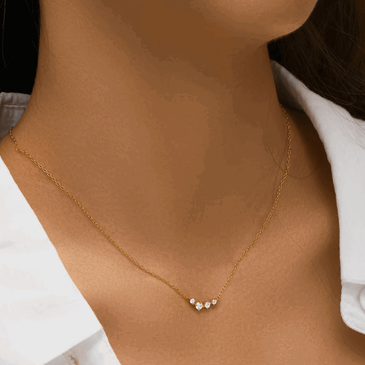 Gold-tone chain necklace with three clear stones in a small dangling cluster