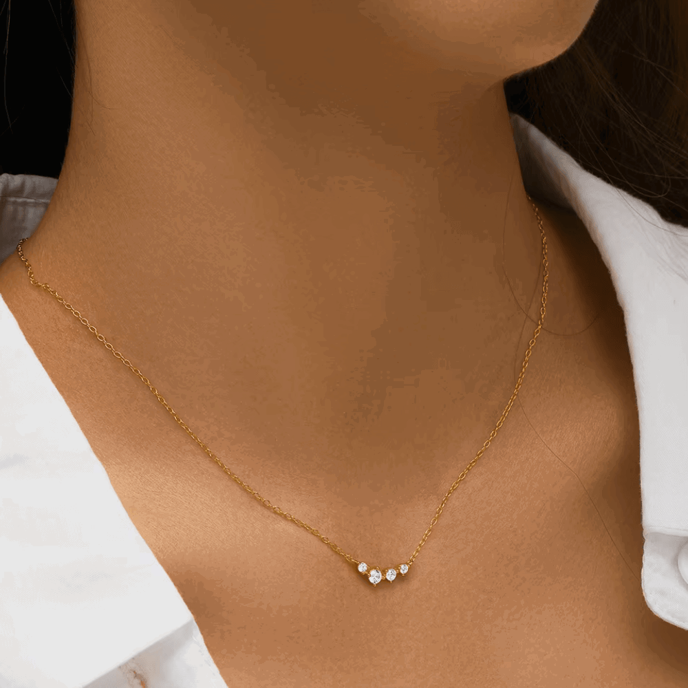 Gold-tone chain necklace with three clear stones in a small dangling cluster